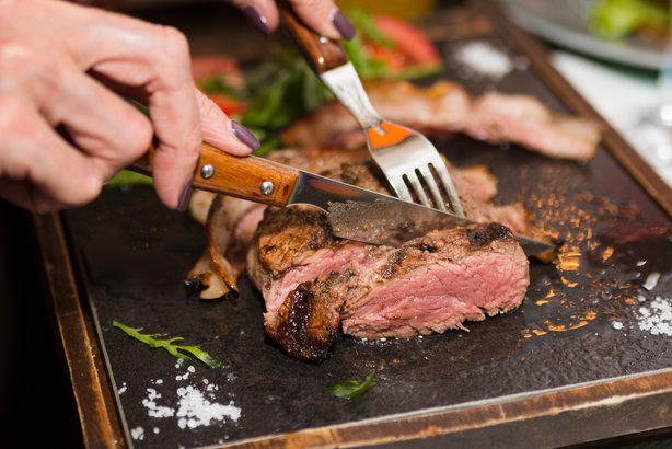 Best Steakhouse In Every State Ism Woman Hand Holding Knife And Fork Cutting Grilled Beef Steak