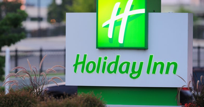 illuminated Holiday Inn sign at dusk