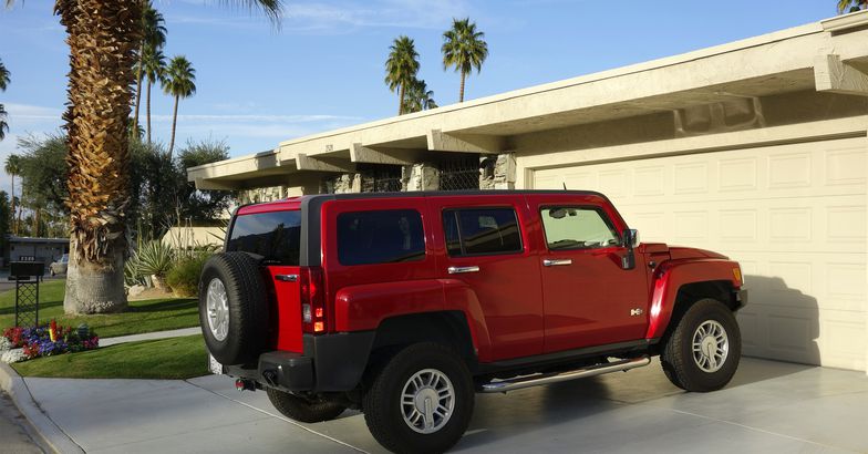 Red Hummer H3 SUV parked on residential diveway