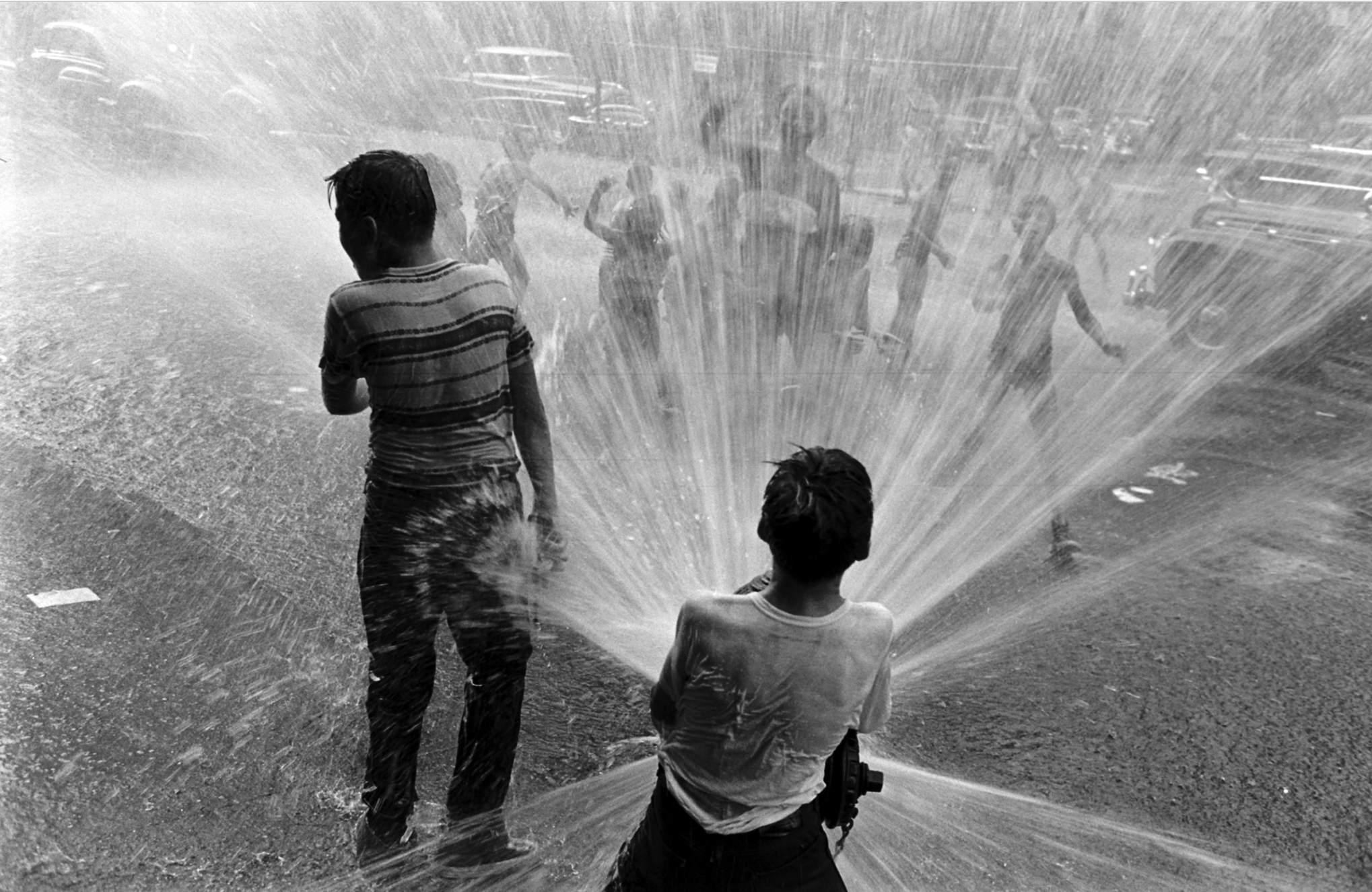 Children playing in water during a heat wave in New York City, 1953.
