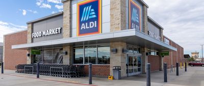 Corner Front Exterior of an Aldi Grocery Store in Pearland, Texas, Carts on the Left and Front Doors on the Right with Lots of Sidewalk Around the Building