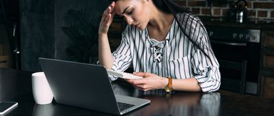 Depressed young woman with calculator 