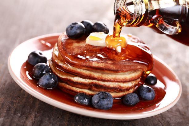 Maple syrup poured over pancakes