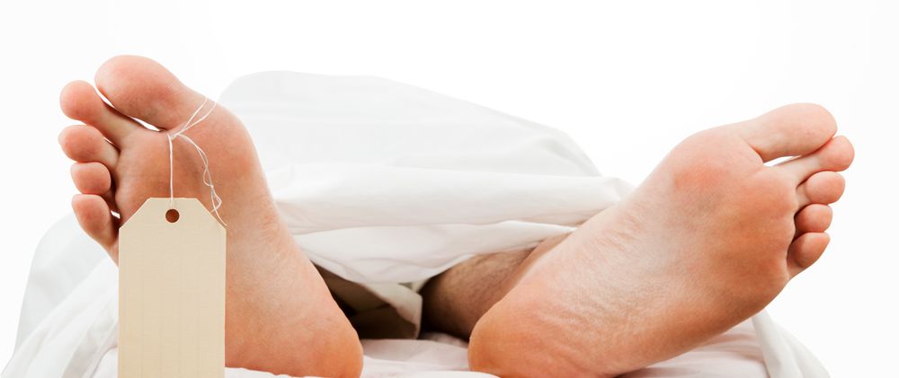 Dead person's feet sticking out from under cloth