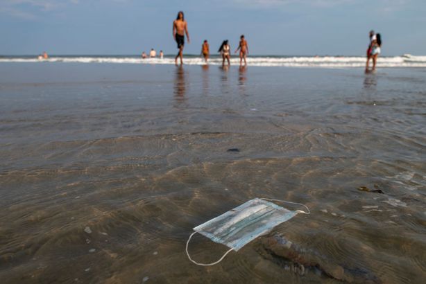 A discarded mask floats in the ocean surf on July 3, 2020 in Wildwood, New Jersey