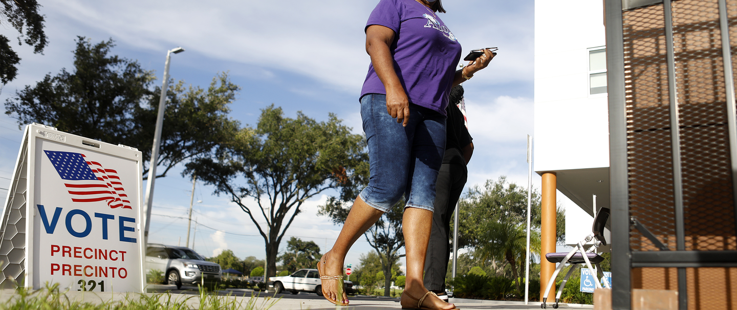 woman walks to voting poll