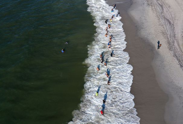 An aerial view of members of the Jetty Fitness Club train in the ocean with what they call a "Life Outside the Box" workout 