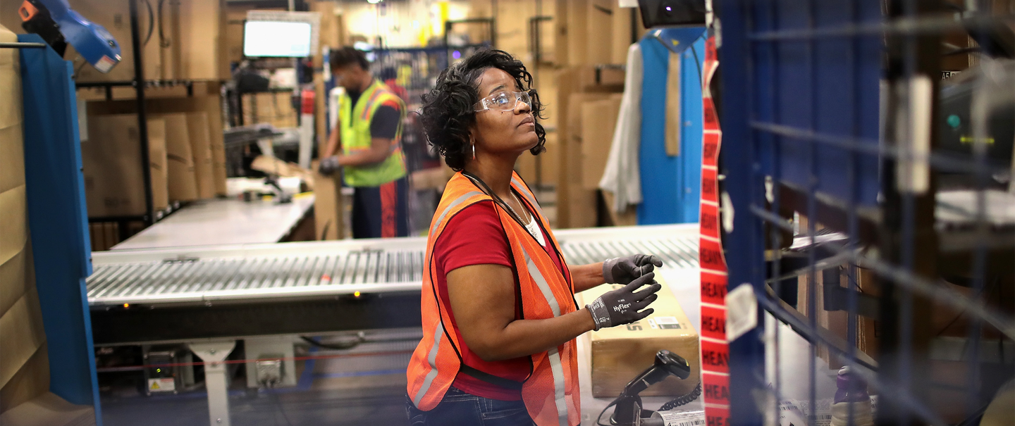 Workers pack and ship customer orders at the Amazon fulfillment center