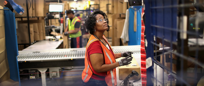 Workers pack and ship customer orders at the Amazon fulfillment center