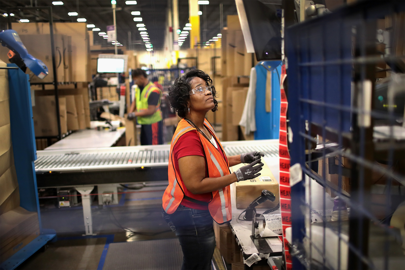 Workers pack and ship customer orders at the Amazon fulfillment center