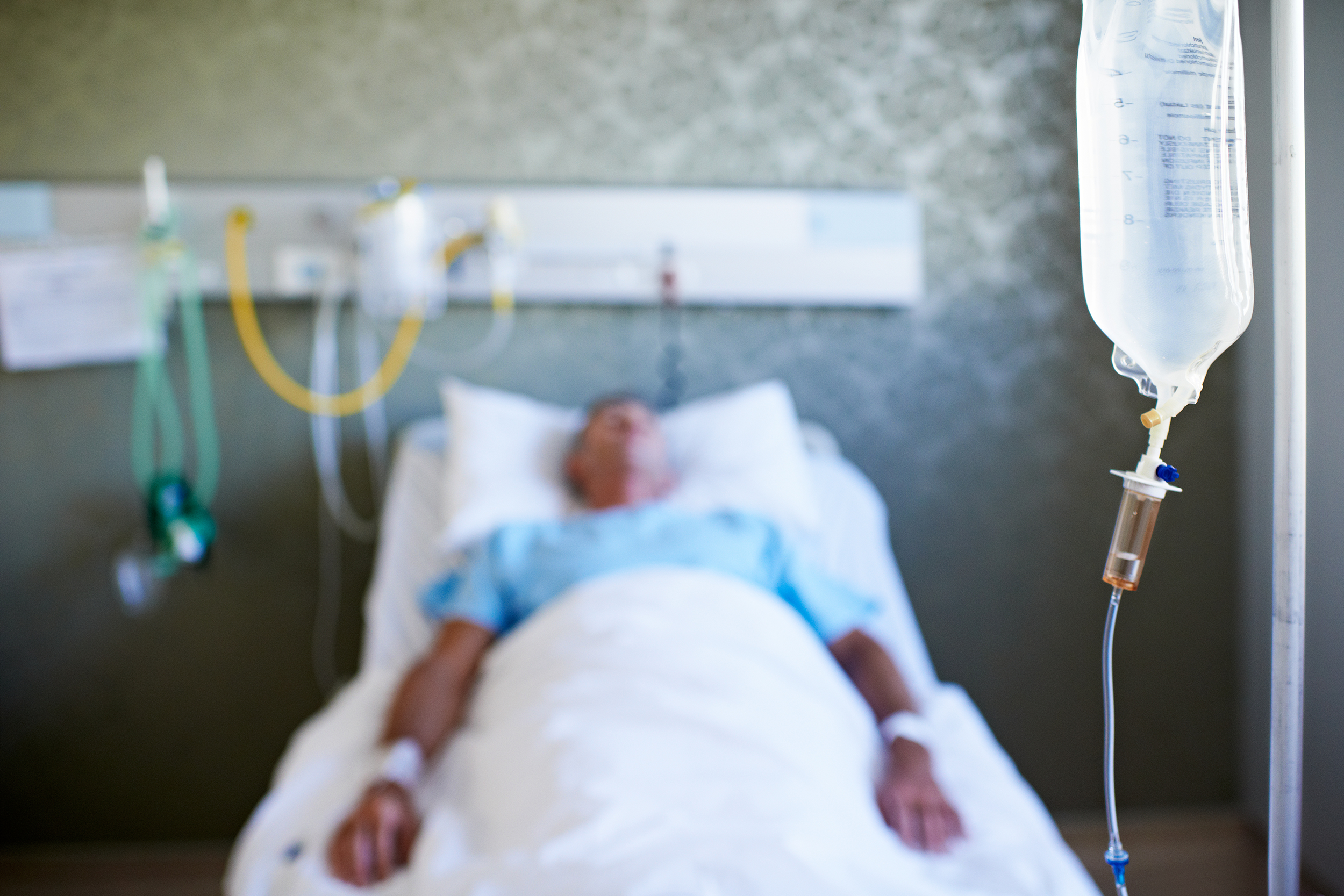 Man lying in a hospital bag with focus on an IV