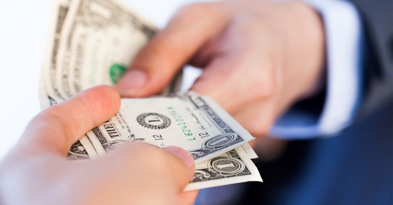 Business man giving money to another person