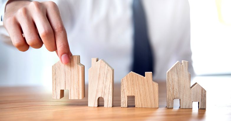Hand of businessman choosing house model
