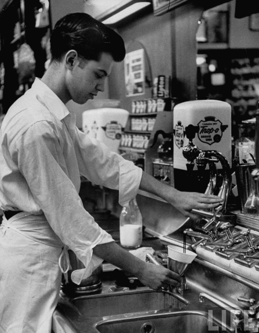 1953 - Soda fountain clerk ("jerk") working behind the counter [Photo by Ralph Morse]