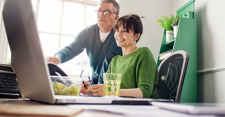 Two mature adults working at home