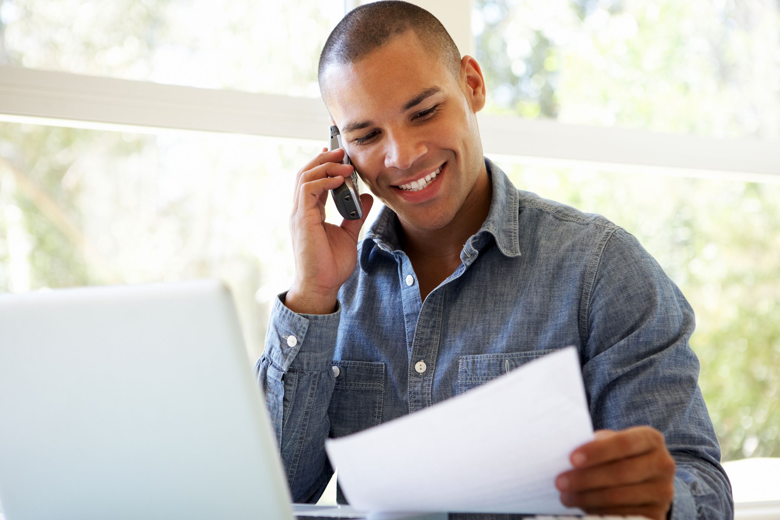 Man on the phone while looking at his bills