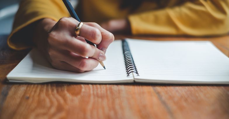 close-up of hands journaling