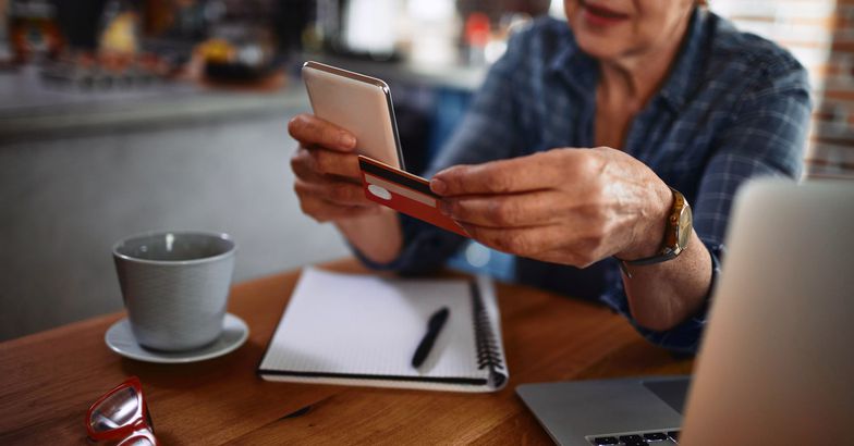 senior holding credit card and phone
