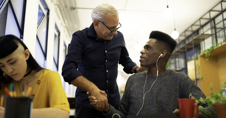 Grateful boss handshaking employee congratulating with career achievement