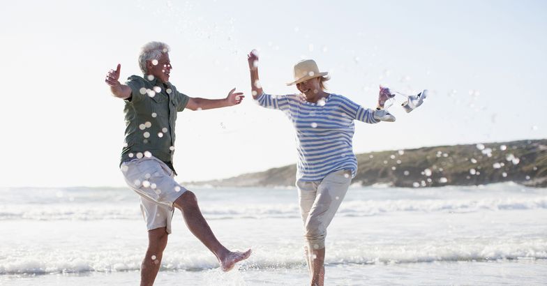 senior couple splashing in ocean