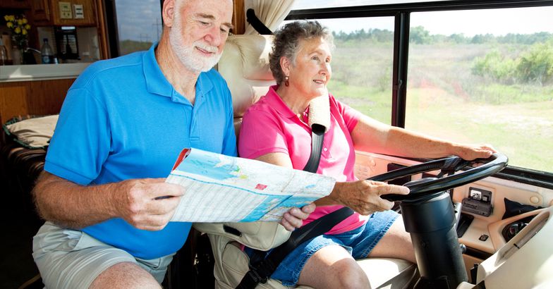 couple driving rv and looking at map