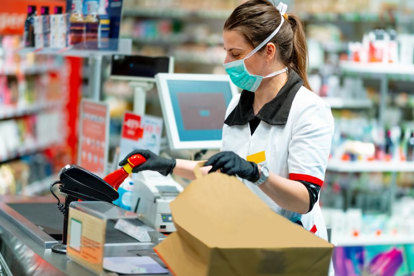 Woman cashier in mask and gloves