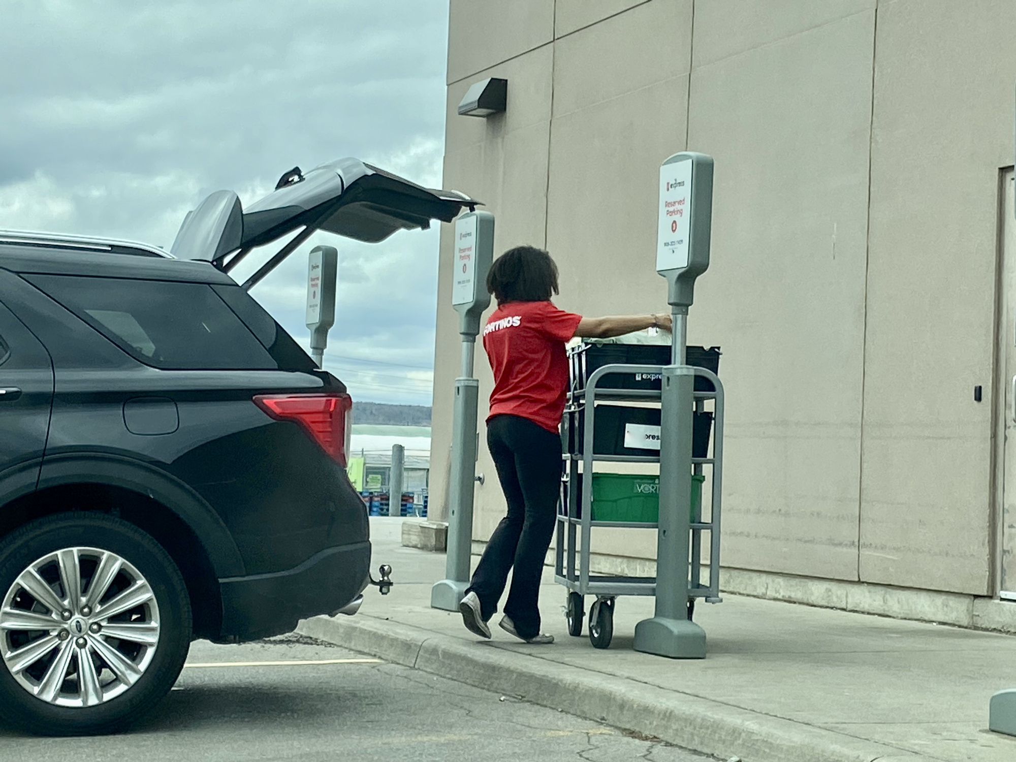 Burlington ON Canada May 11 2020: An essential worker loading groceries ordered online to prevent social contact in store.