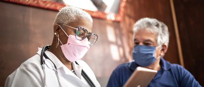 Doctor talking to senior male patient in a home visit