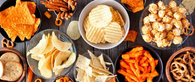 Assortment of salty snacks, top view table scene over wood