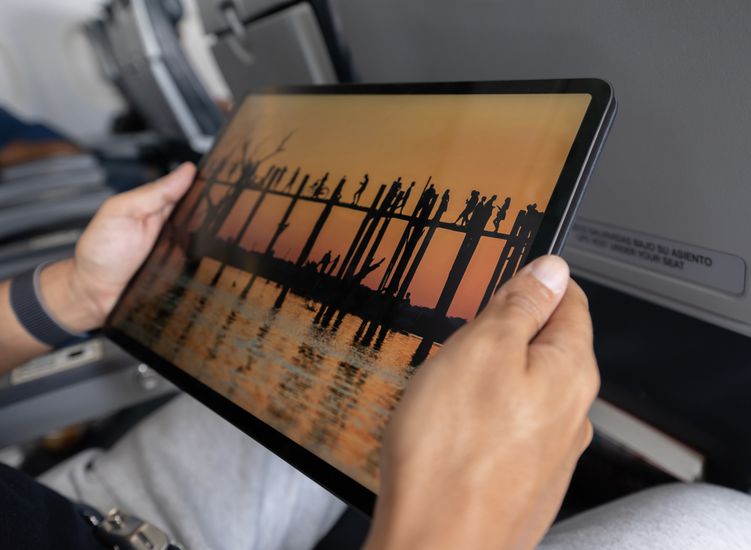 Close-up on a traveler watching a movie in an airplane using his tablet