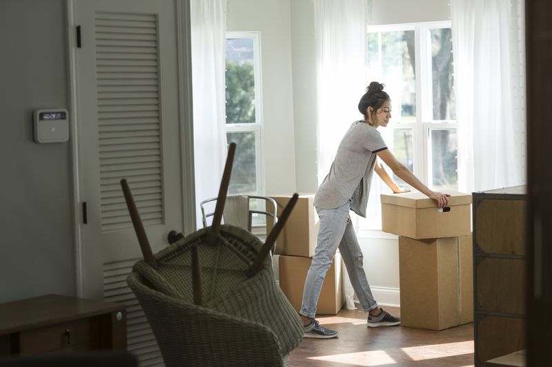 Young mixed race woman moving into new home