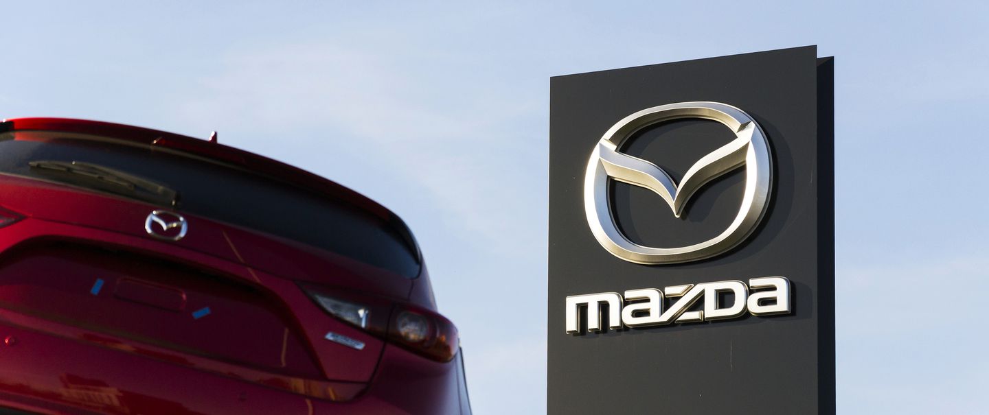 Mazda 3 car in front of dealership building